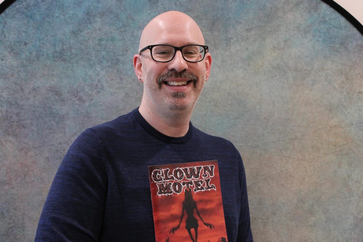 Robert Brandt, who teaches film study at CT State Manchester, holds a copy of "Clown Motel," his recently published horror graphic novel.