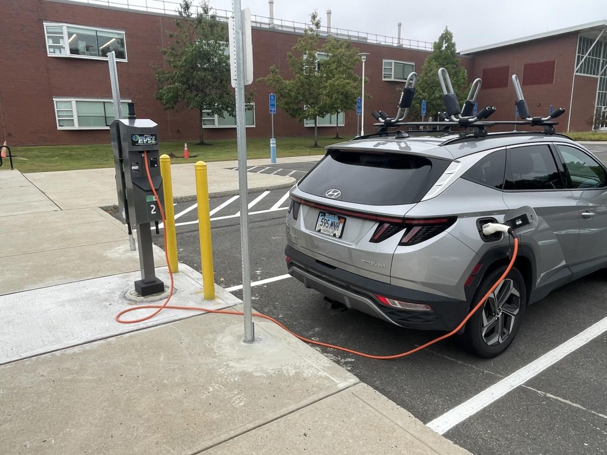 Nora Uricchio, who teaches radiation therapy at Manchester, uses an EV station to charge her hybrid Hyundai Tucson.