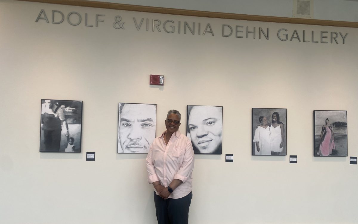 Deb Simmons stands in front of some of the photos in her "The Living Archive" exhibit in the AST building.